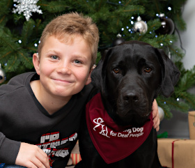 a young boy and a black labrador