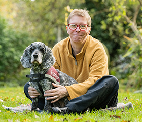 Lorna and cocker spaniel Belle are sitting next to each other on the grass