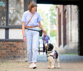 A woman walking outdoors with a dog