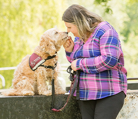Mary with hearing dog Harley sitting down