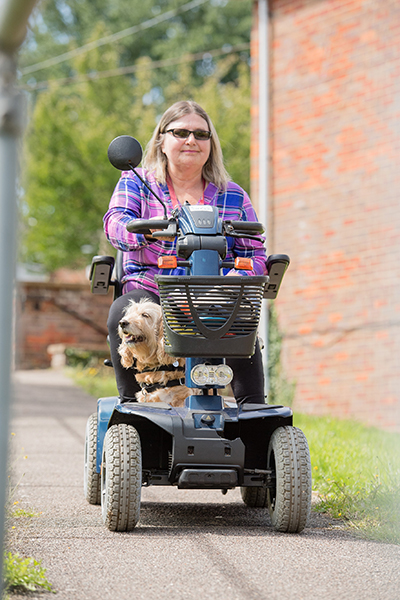 Mary and hearing dog Harley on a motorised scooter