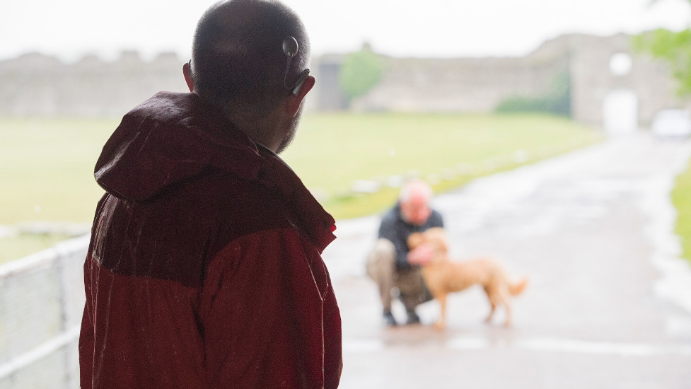 Richard looks on at another dog owner with their pet in the distance