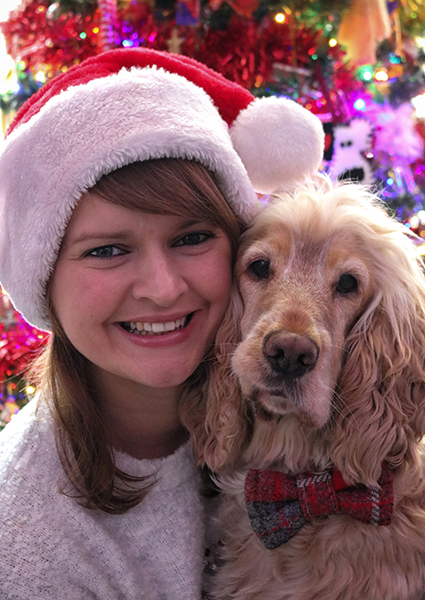 Sarah and hearing dog Albert in front of a Christmas tree