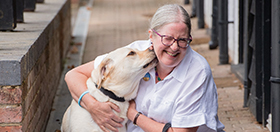 Hearing dog Kit is licking Jill's face