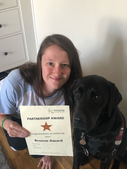 Erin and hearing dog Otis with their certificate for passing their Bronze Partnership award