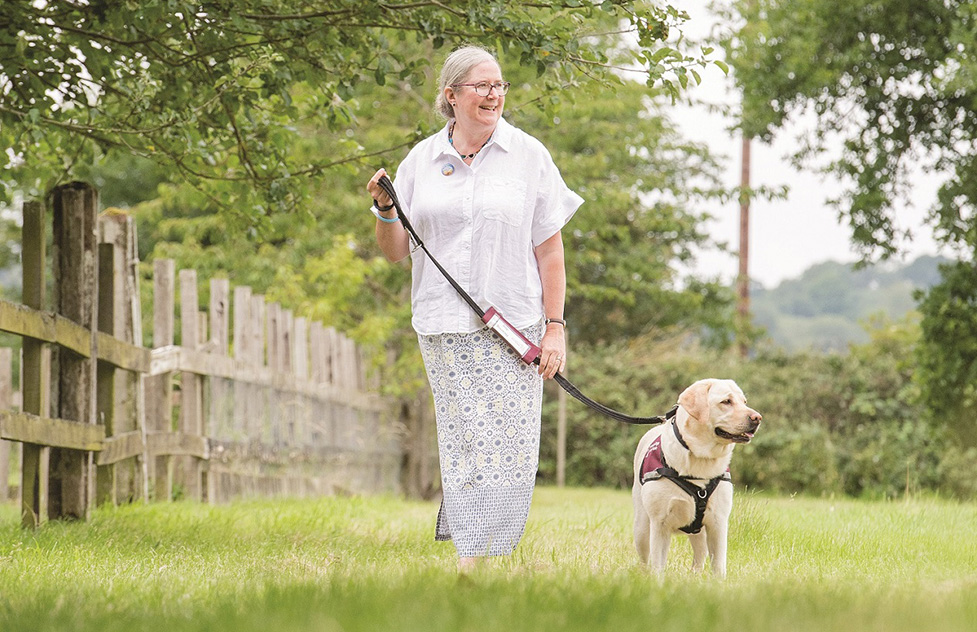 Jill and her hearing dog Kit walking together outside