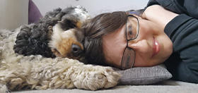 Cocker spaniel Archer lying down next to his partner Rachel with their heads touching