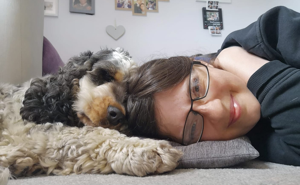Cocker spaniel Archer lying down next to his partner Rachel with their heads touching