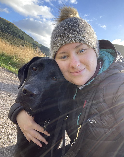 Lauren cuddling hearing dog Douglas