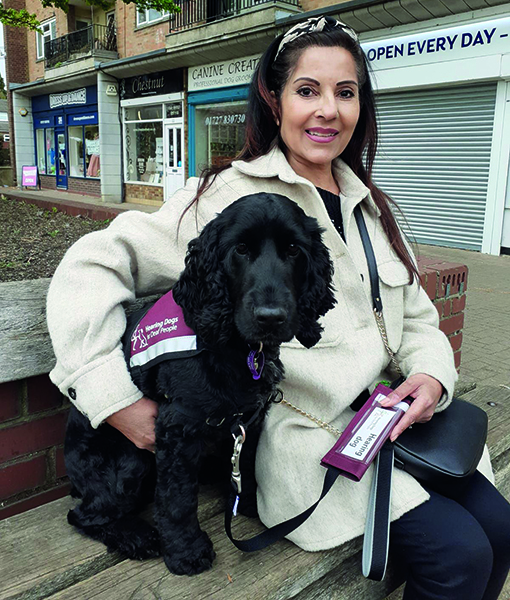 Shmita and hearing dog Harris sitting outside on a high street